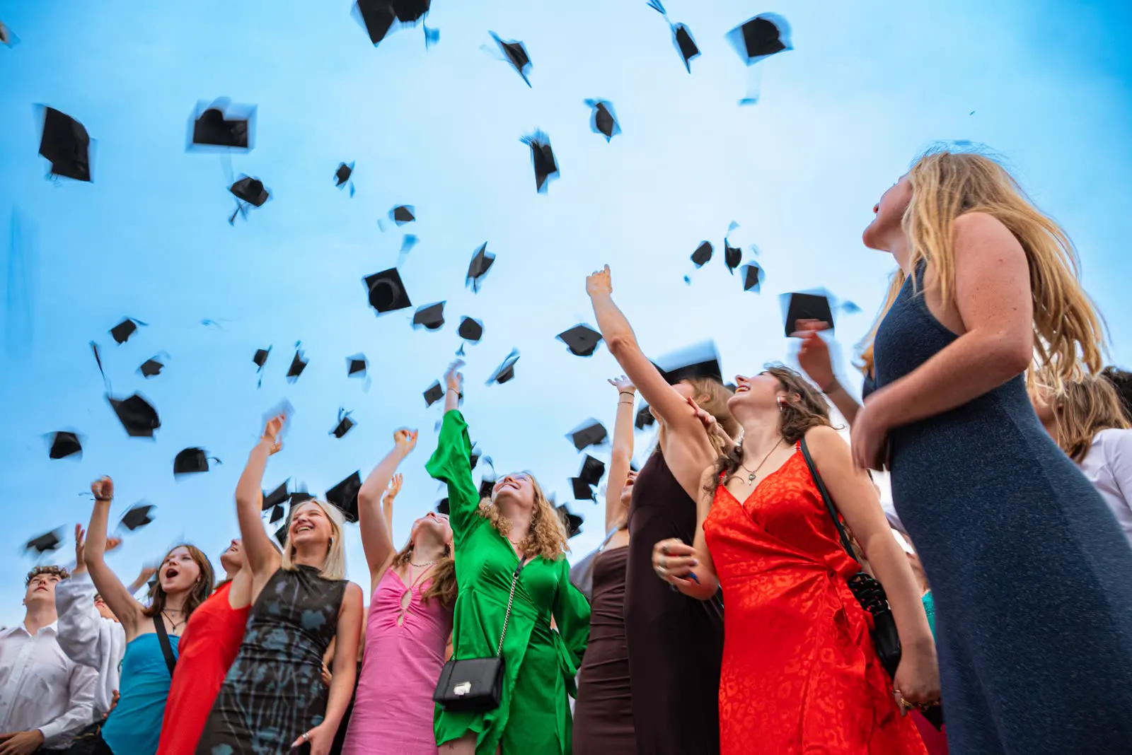 Studenti che lanciano il tocco di laurea al cielo